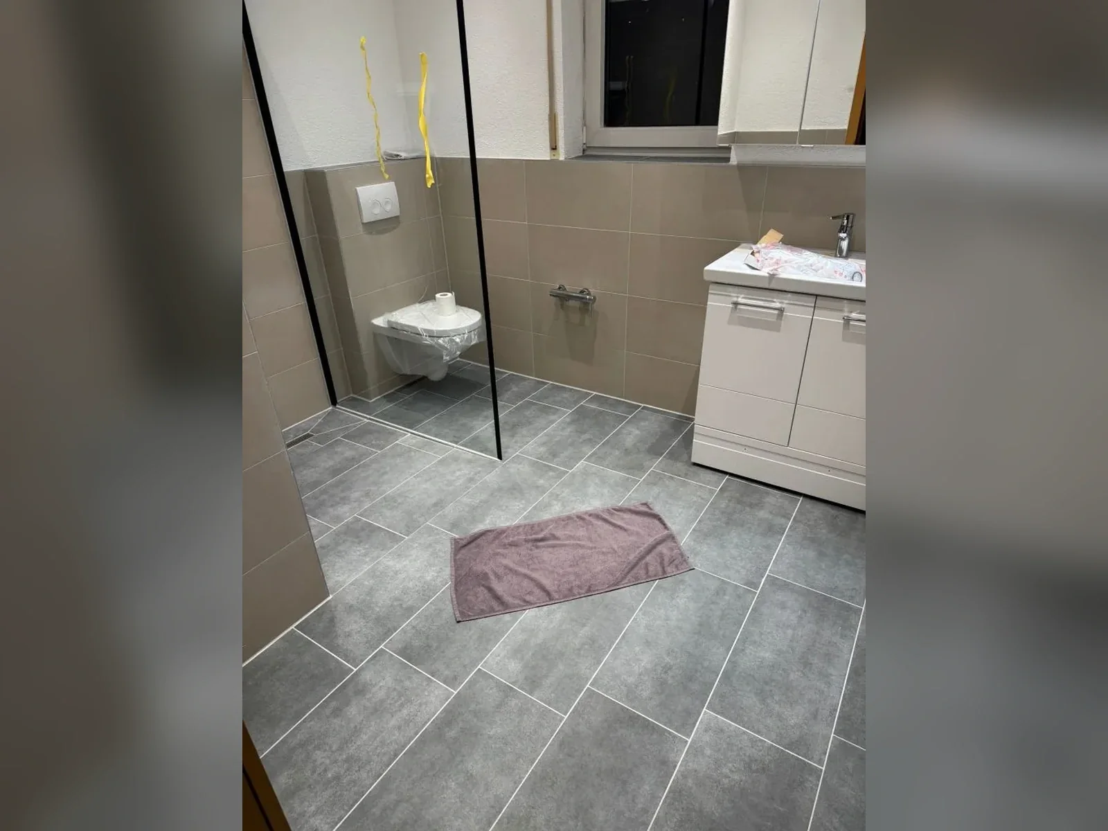 Fertig saniertes Badezimmer mit bodengleicher Dusche nach der Modernisierung