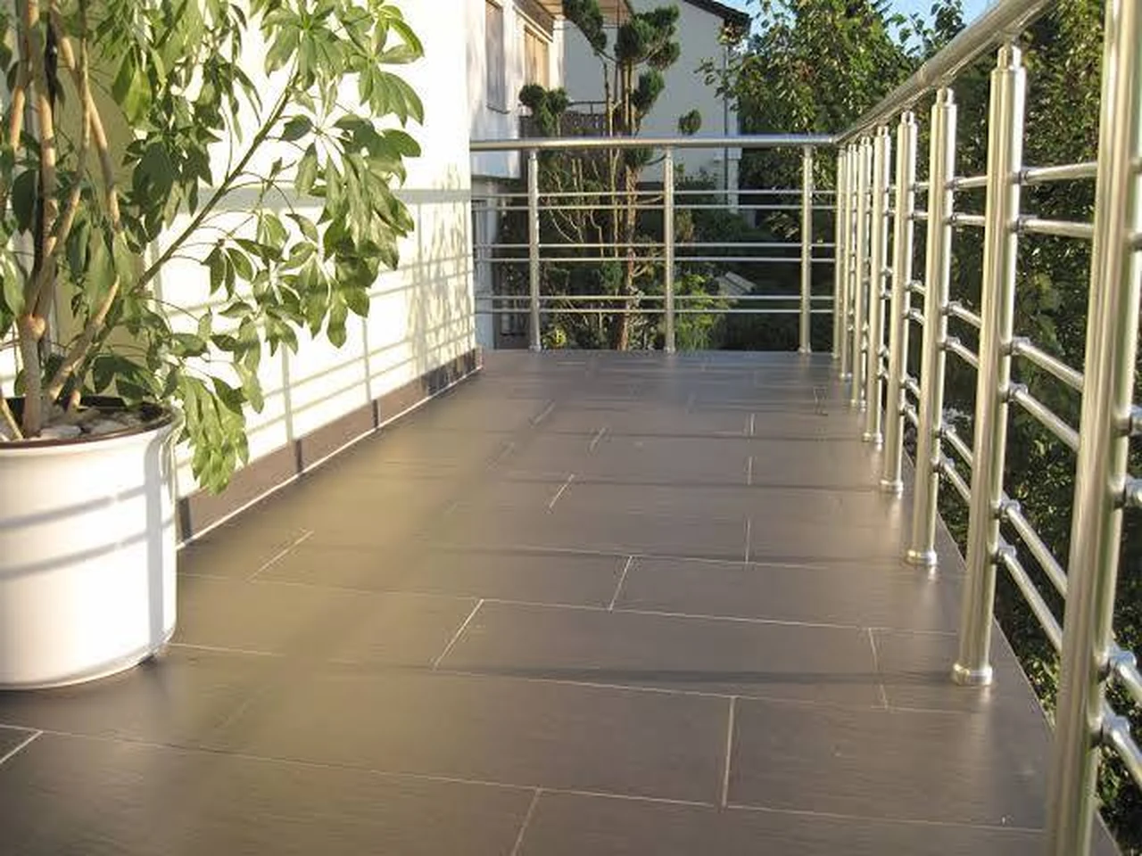 Sanierter Balkon mit großformatigen Fliesen und Edelstahlgeländer