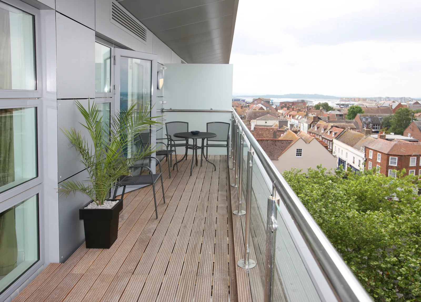 Modern sanierter Balkon mit hochwertigem Bodenbelag und Glasgeländer